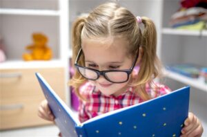 criança lendo no cantinho da leitura